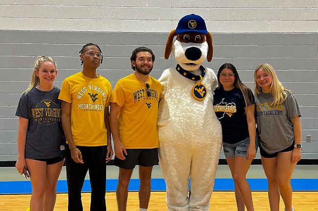 Students pose with Musket mascot at the Day of Play event