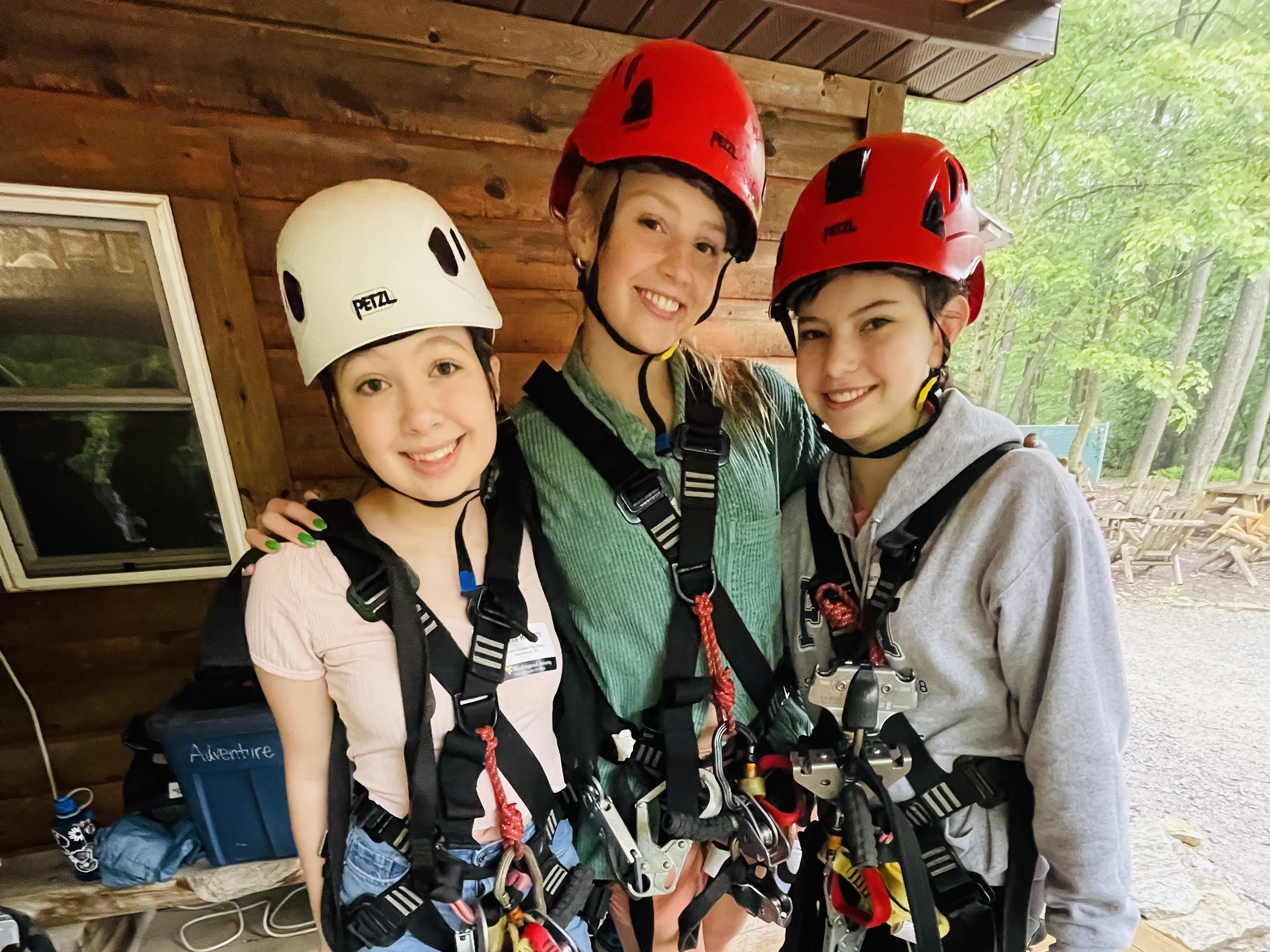 Three students pose in zip line gear