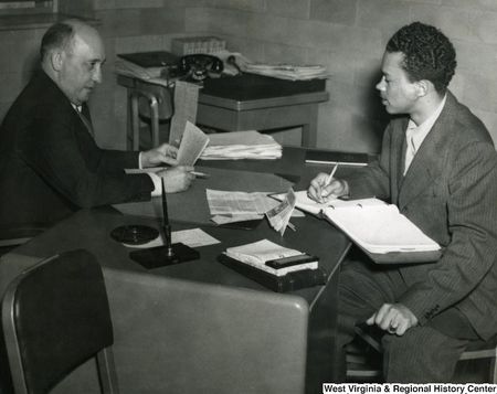Old photo of Black student interviewing a white man 