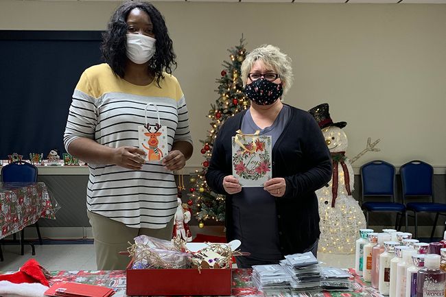 Two women put together holiday gift bags