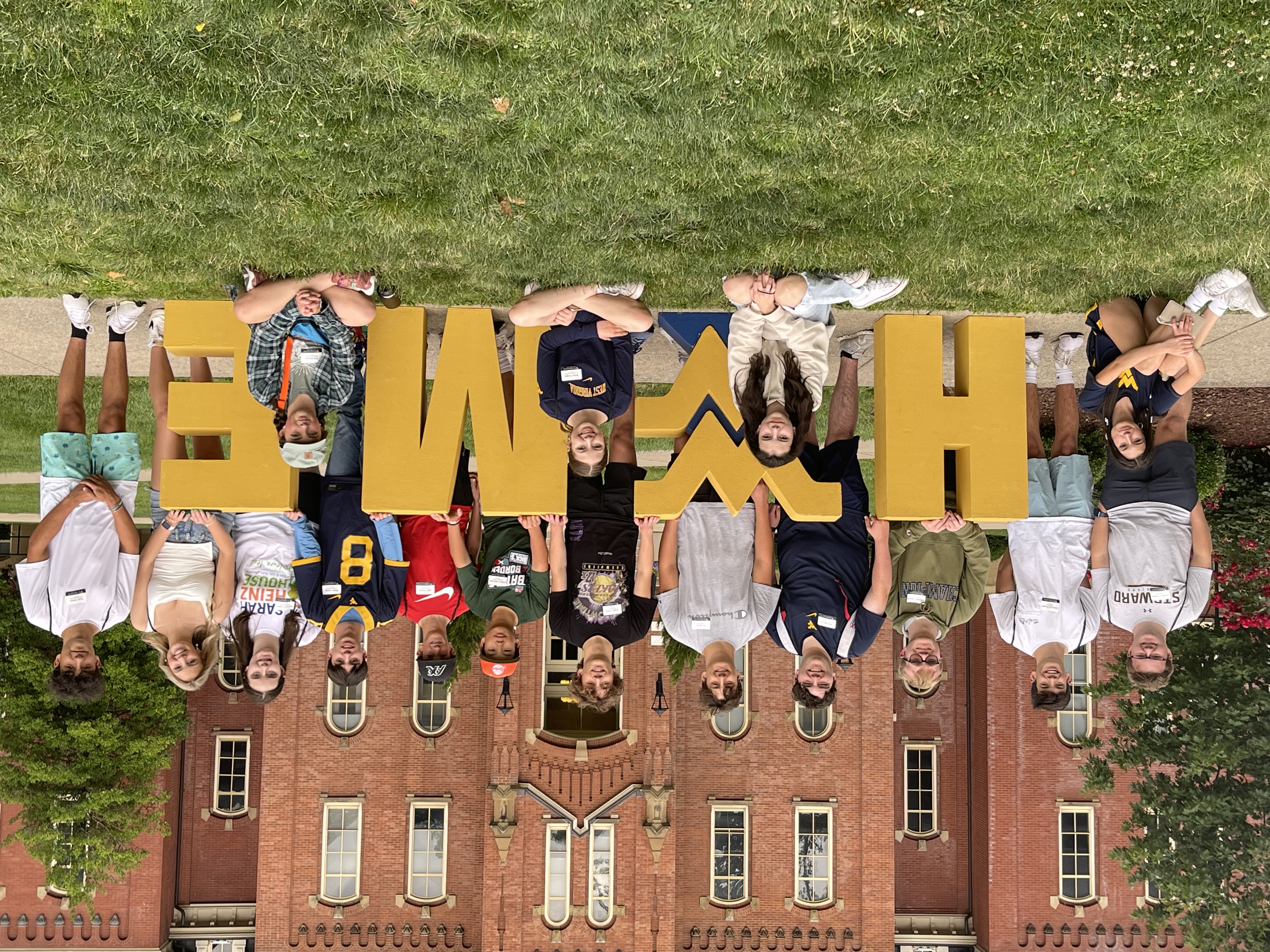Students pose with HOME sign in WVU Woodburn Circle