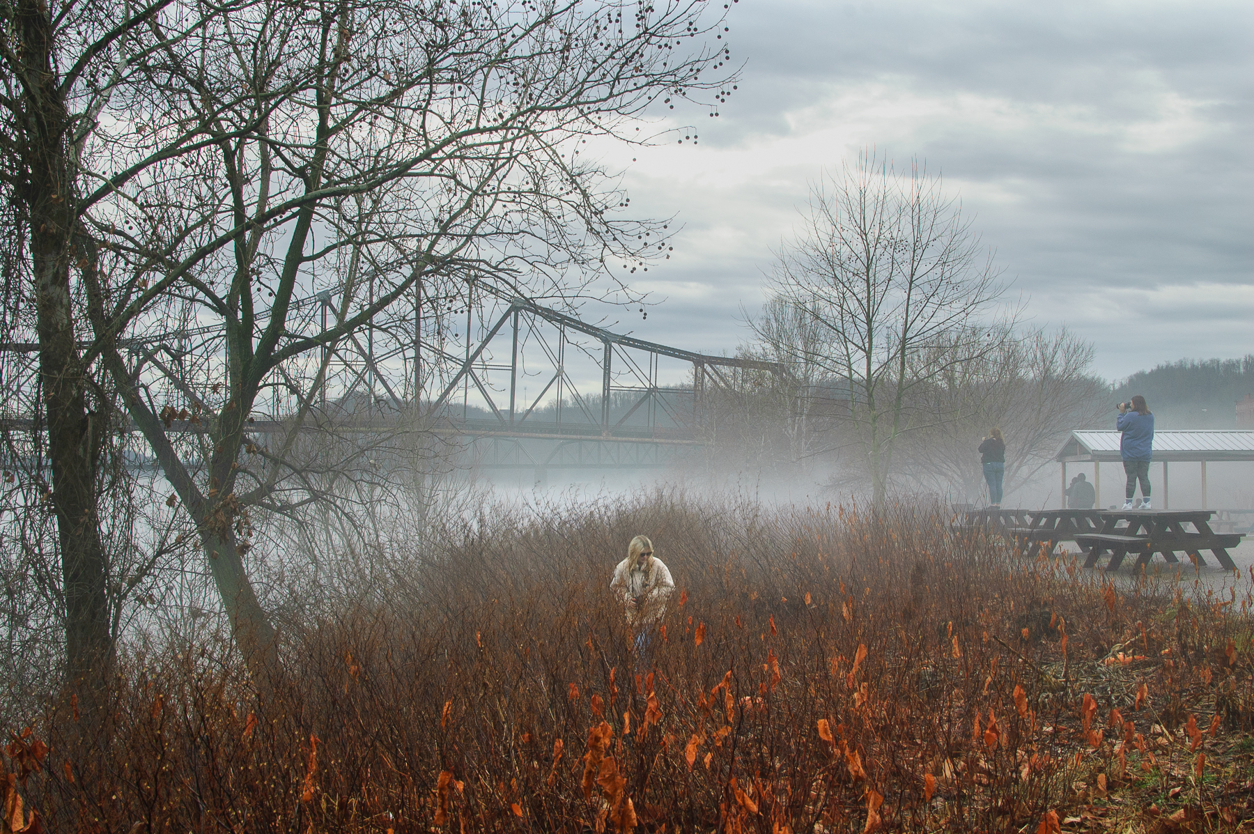 Students photograph area by a bridge along river in Ohio Valley with early morning mist