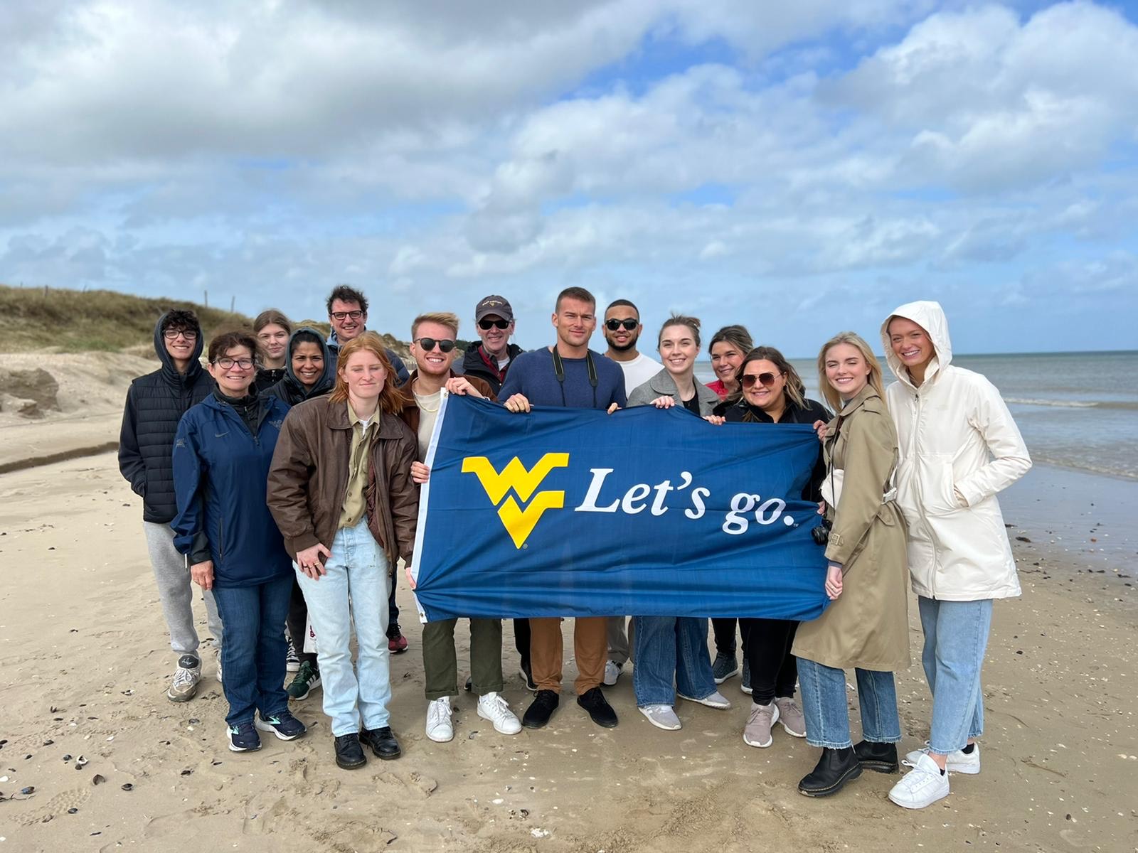 Students pose with WVU flag in Normandy, France